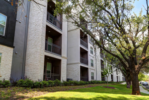 Photo of Exterior with Green Grass and Trees beneath balcony at Martha's Vineyard Place Apartments